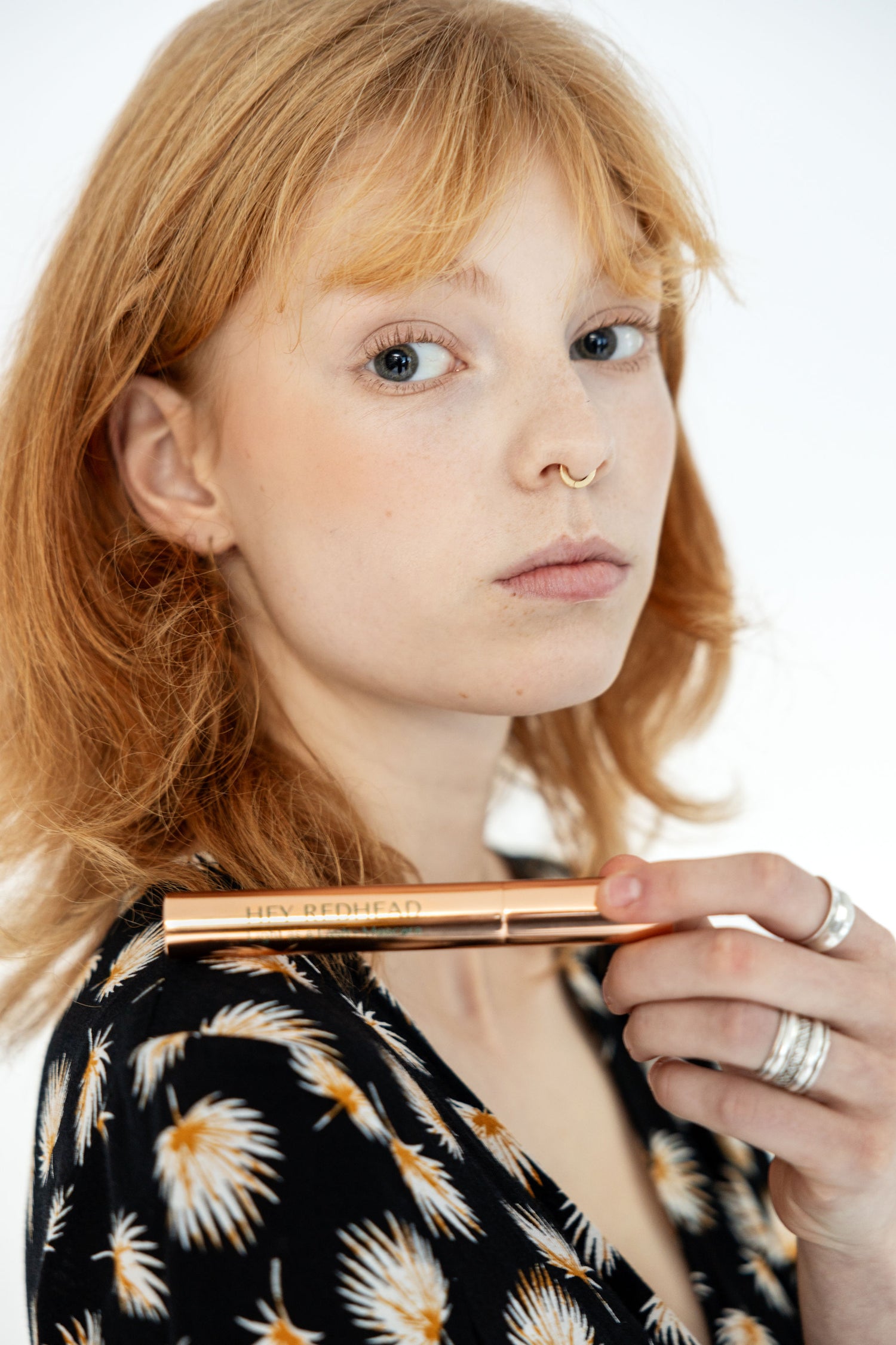 Hey redhead model bjork holding Gingerlicious mascara on left shoulder.  
