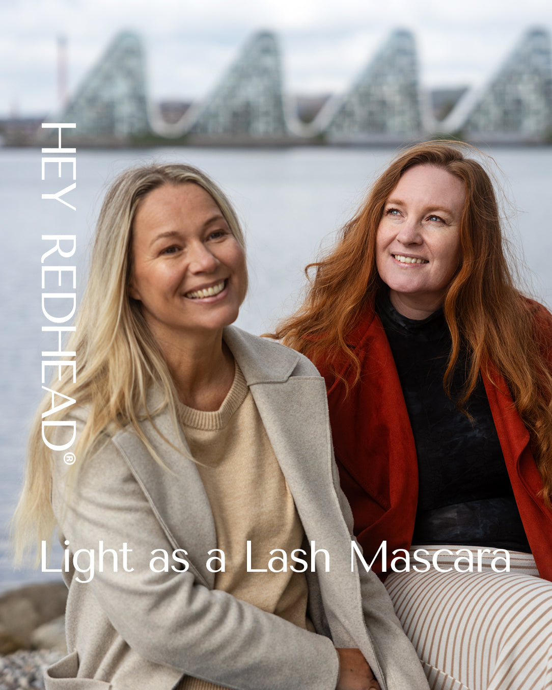 Two woman in Denmark with harbour water background, the Wave, from Vejle with brand text for HEY REDHEAD® Mascaras as graphic elements. 
